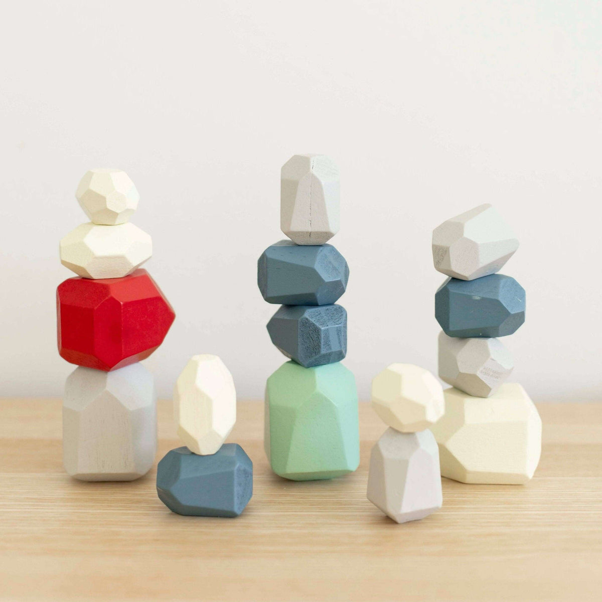 Set of colorful geometric wooden toys on a light surface with a white background