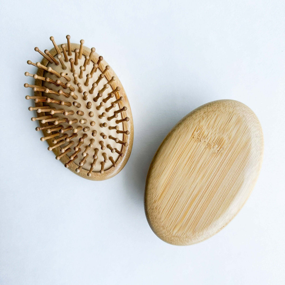 Wooden hairbrush and wooden soap on a light gray background