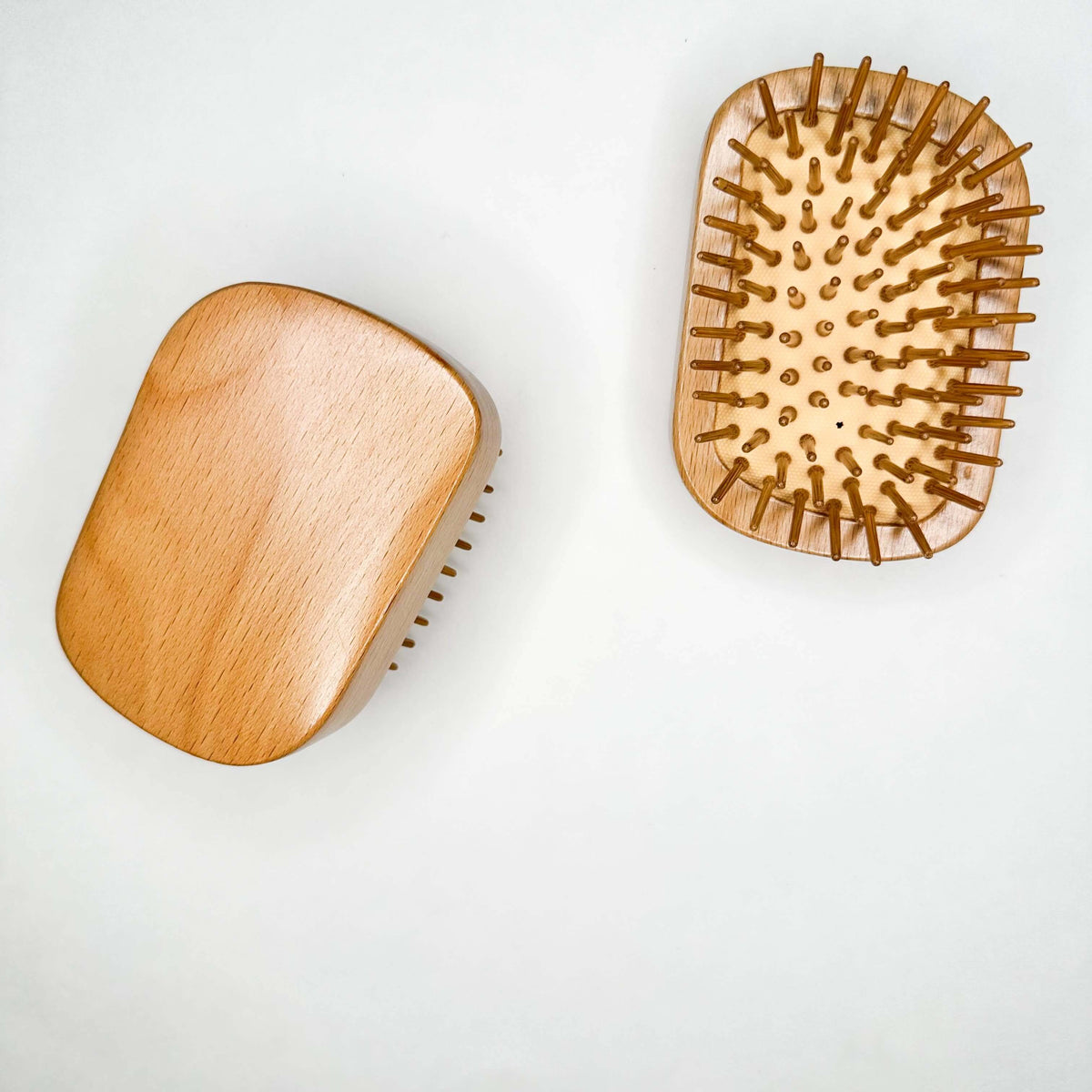 Two wooden hairbrushes on a white background