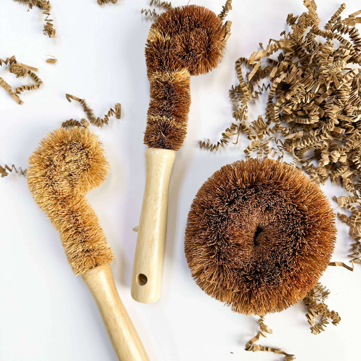 Set of natural fiber brushes with wooden handles on a white background