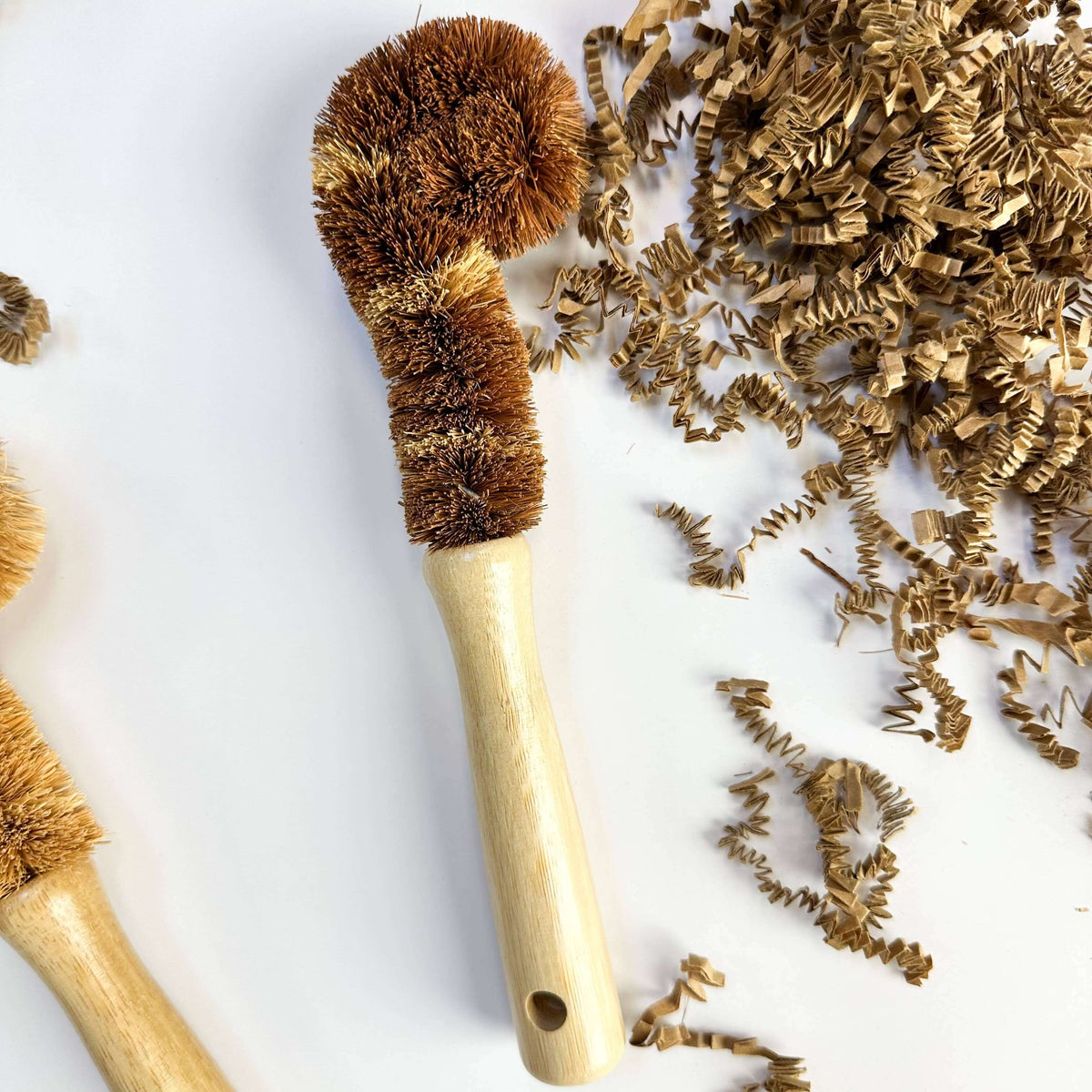 Bristle brush with wooden handle surrounded by bristle碎片 on a white background