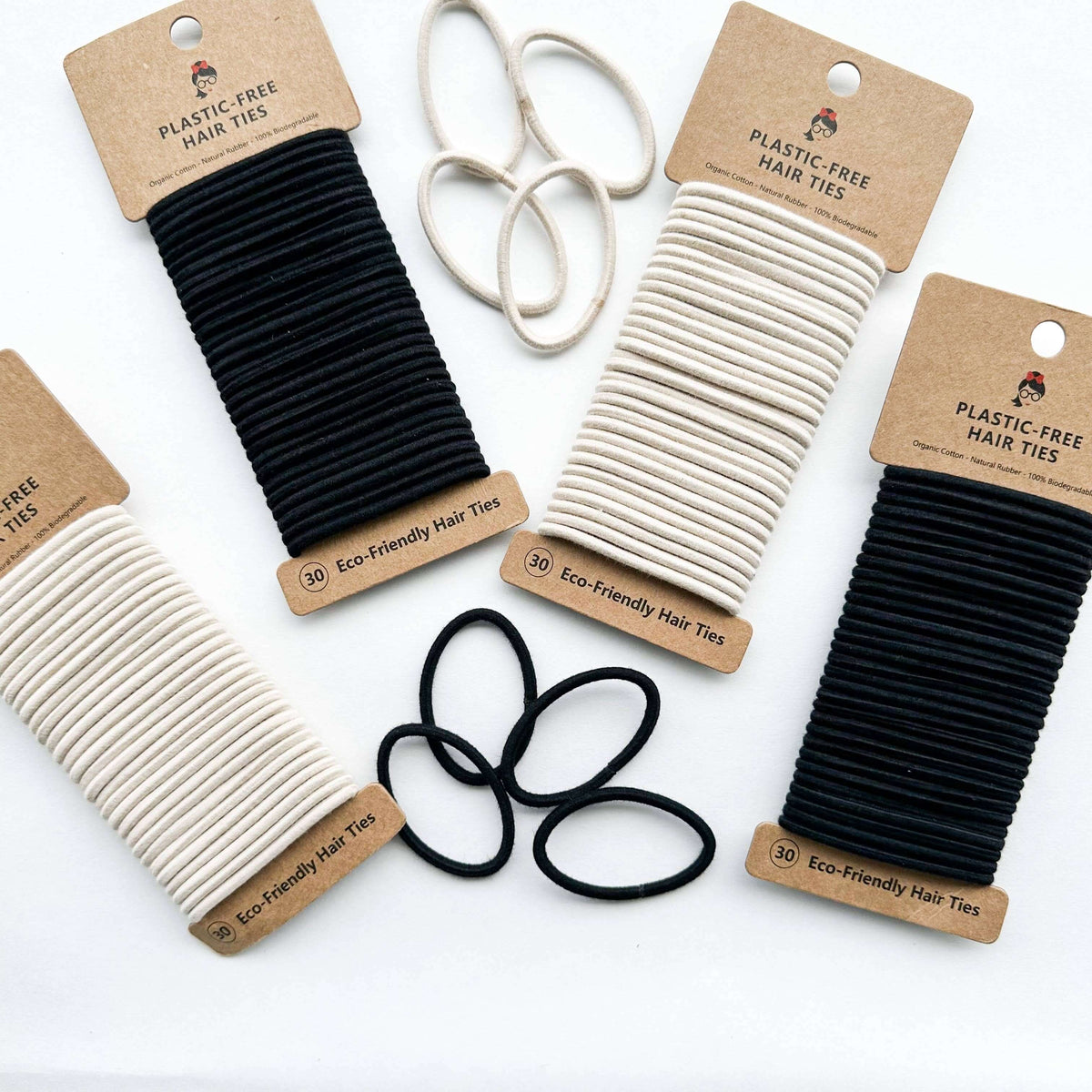 Plastic-free hair ties in black and beige with cardboard packaging on a white background