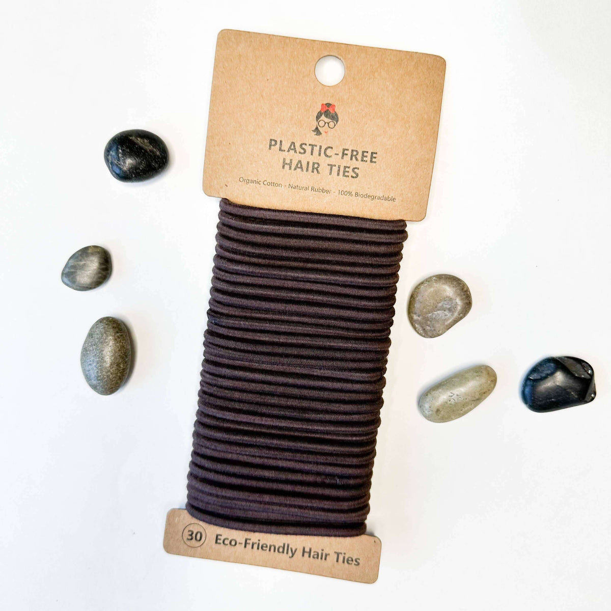 Eco-friendly hair ties on a cardboard packaging with rocks on a white background