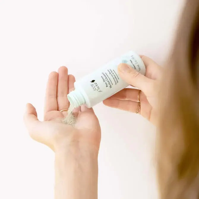 Person pouring Pore Detox Herbal Cleanser, a gentle herbal cleanser, into their hand from a bottle.