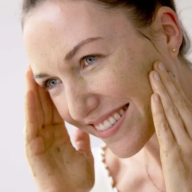 Woman applying Pore Detox Herbal Cleanser, enjoying a refreshing herbal cleanse for glowing skin.