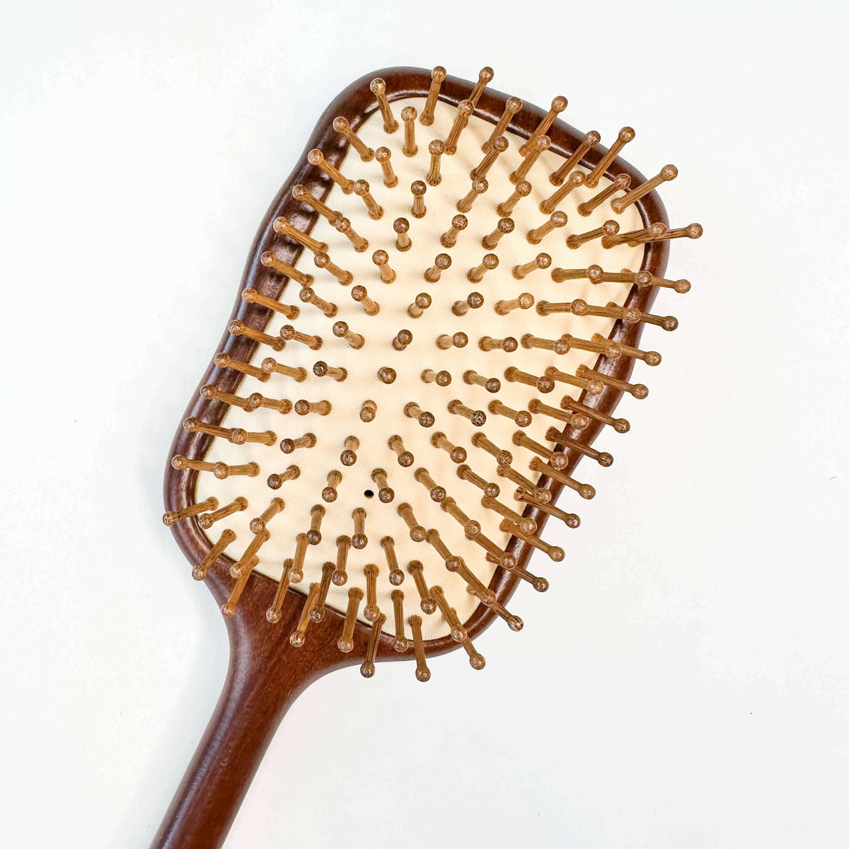 Wooden hairbrush with bristle head on a white background