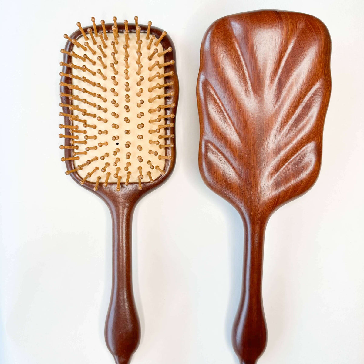 Wooden hairbrushes with paddle and brush designs on a white background