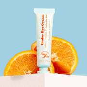 Tube of 'Under Eye Cream' with oranges on a light blue background