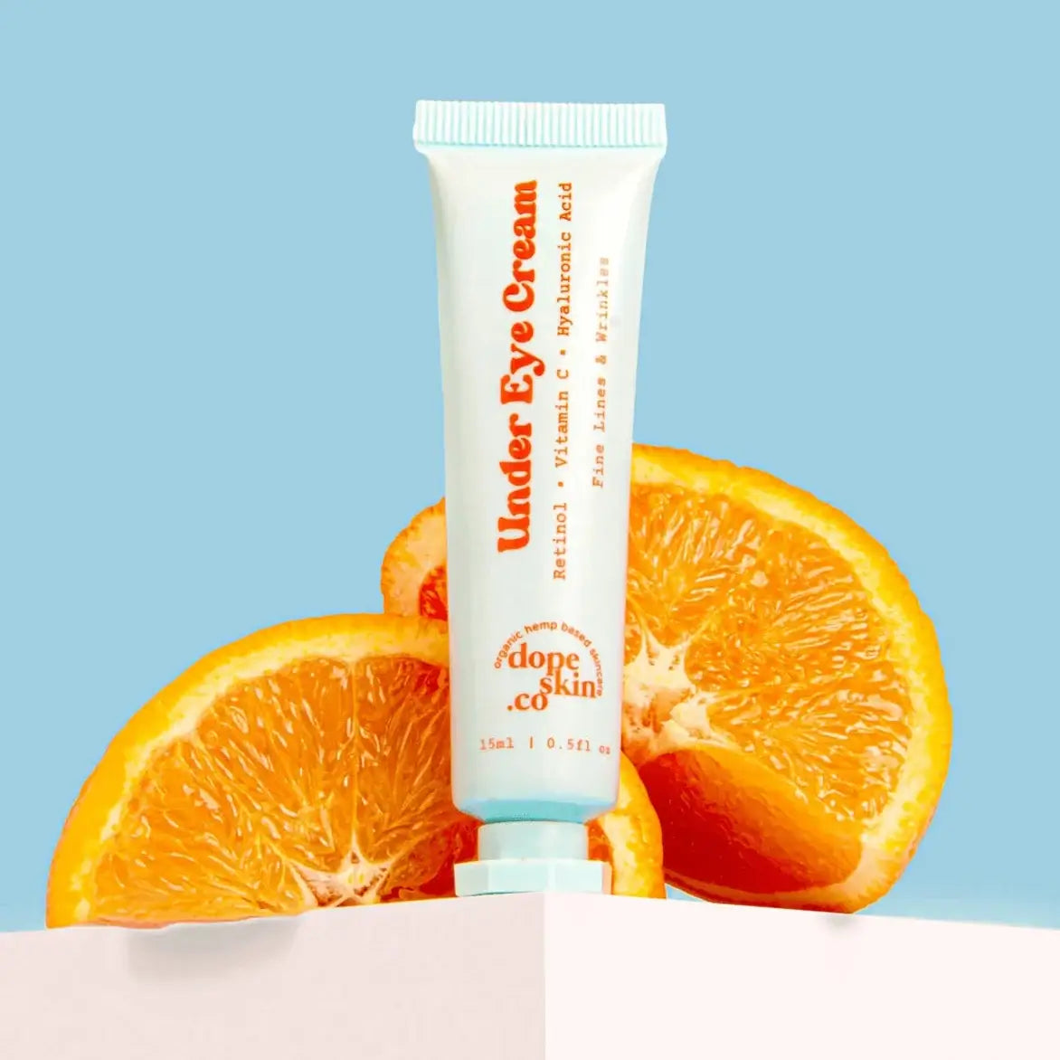 Tube of 'Under Eye Cream' with oranges on a light blue background