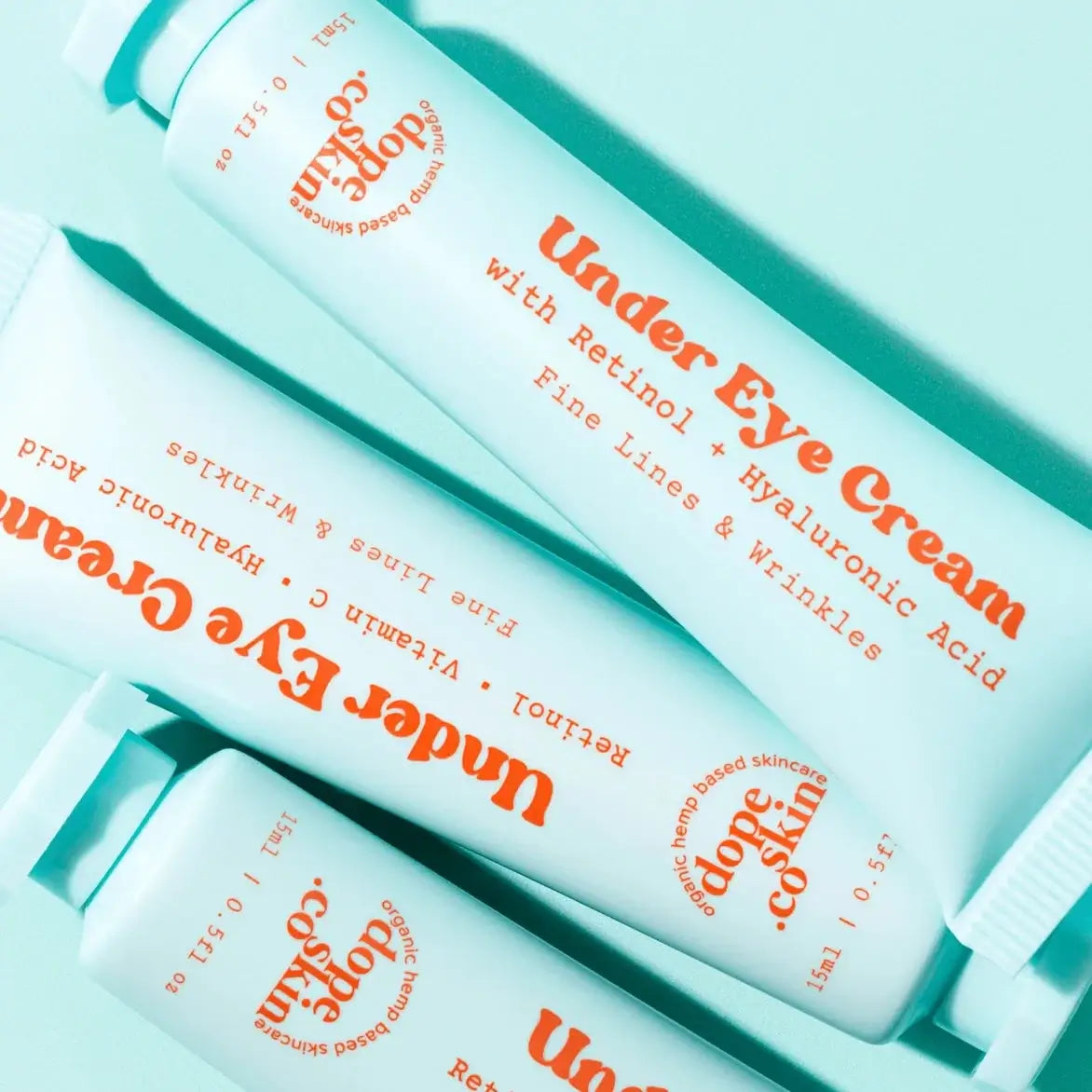Three bottles of Under Eye Cream with Retinol and Hyaluronic Acid on a light blue background.