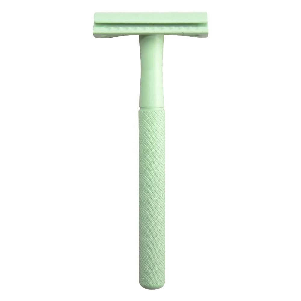 Green safety razor on a white background