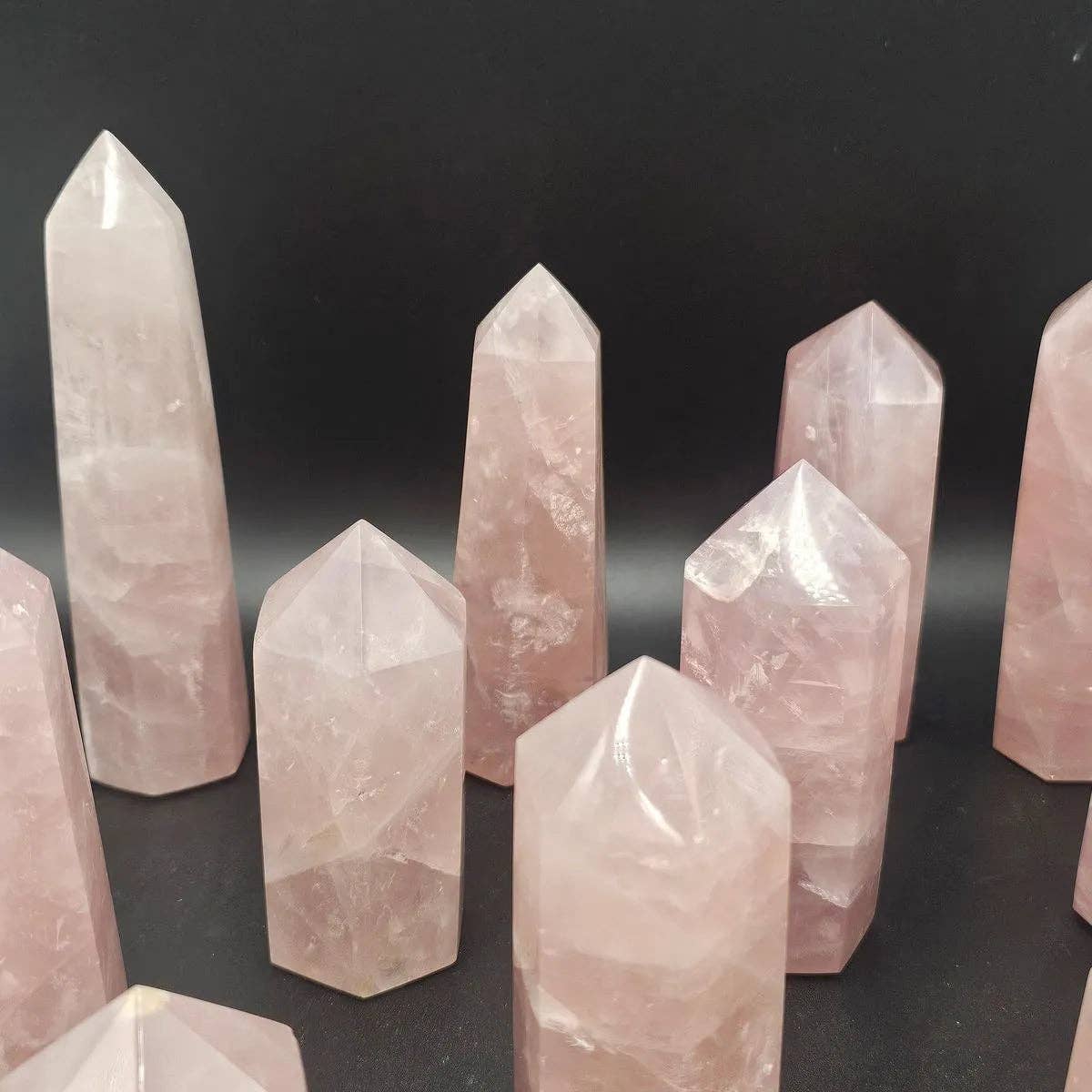 Rose Quartz Crystal Towers showcasing unique hand carved designs and natural pink hues on a black background.