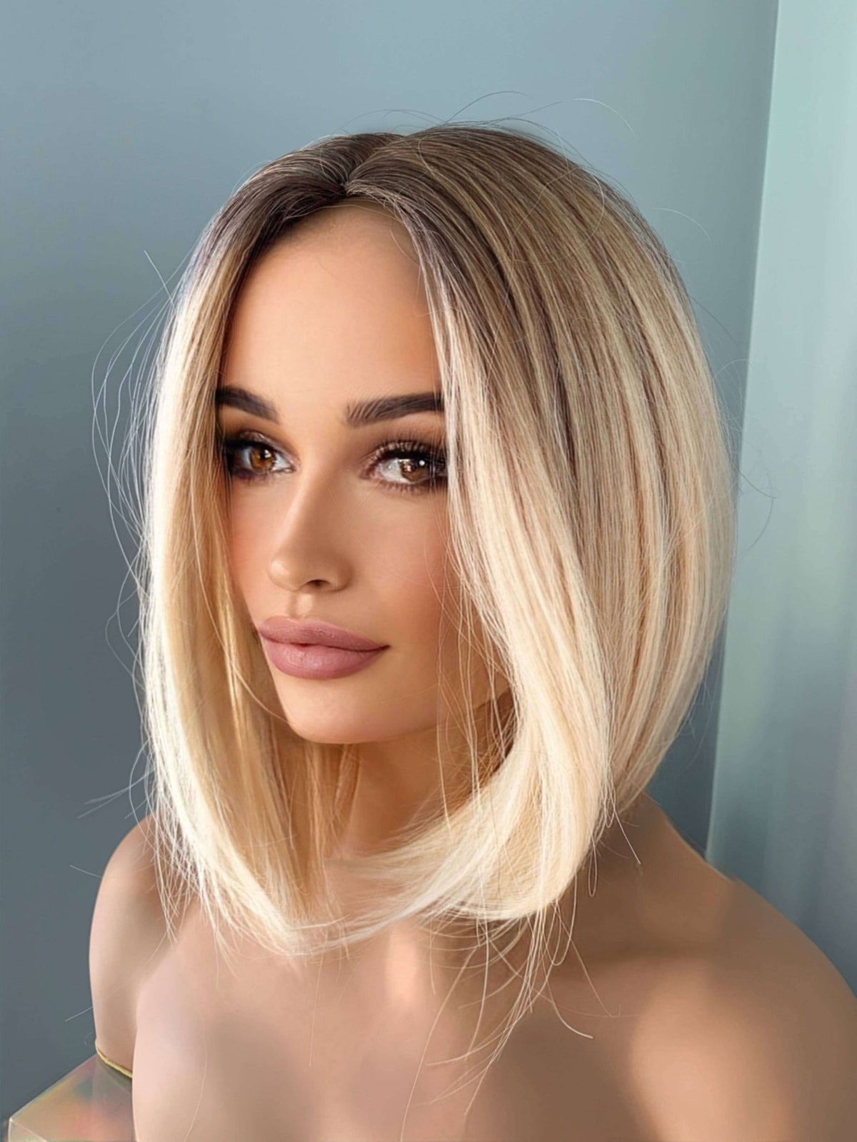Sadie Short Blonde Rooted Wig, featuring a sleek angled bob cut and a polished, face-framing silhouette.