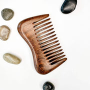 Wooden comb with stones on a white background