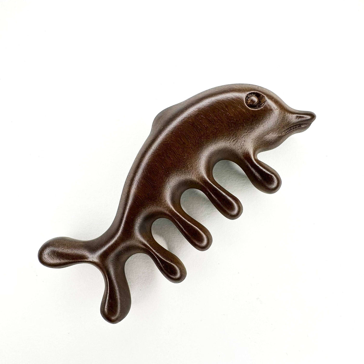 Brown dolphin-shaped comb on a white background