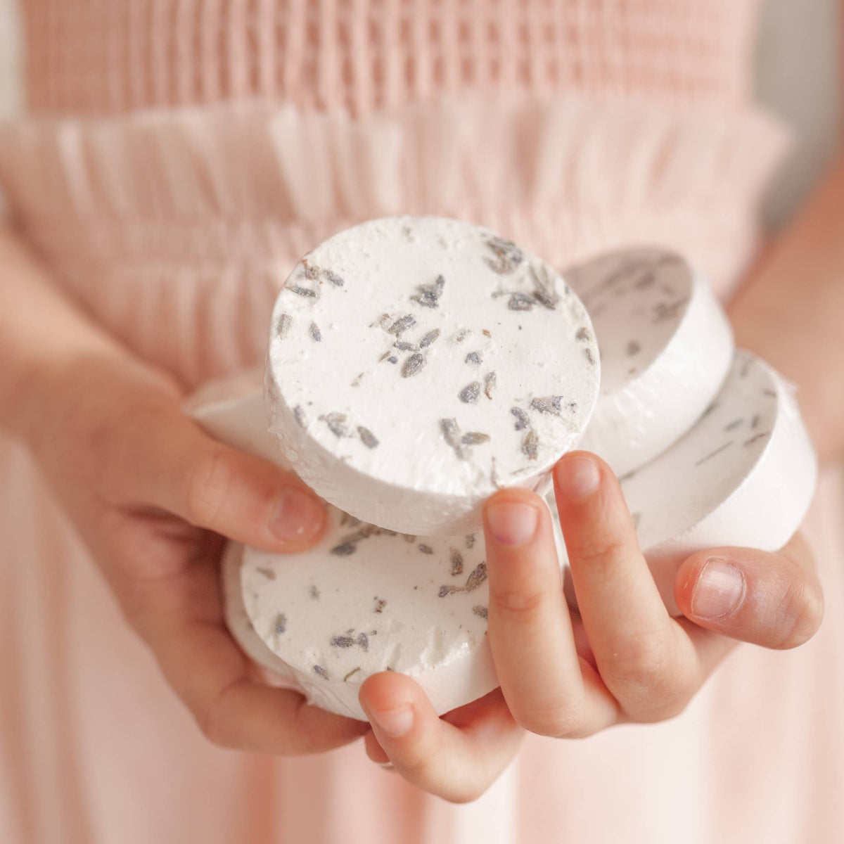 Person holding Sensory Shower Steamers x 6, infused with calming lavender aroma for a relaxing shower experience.