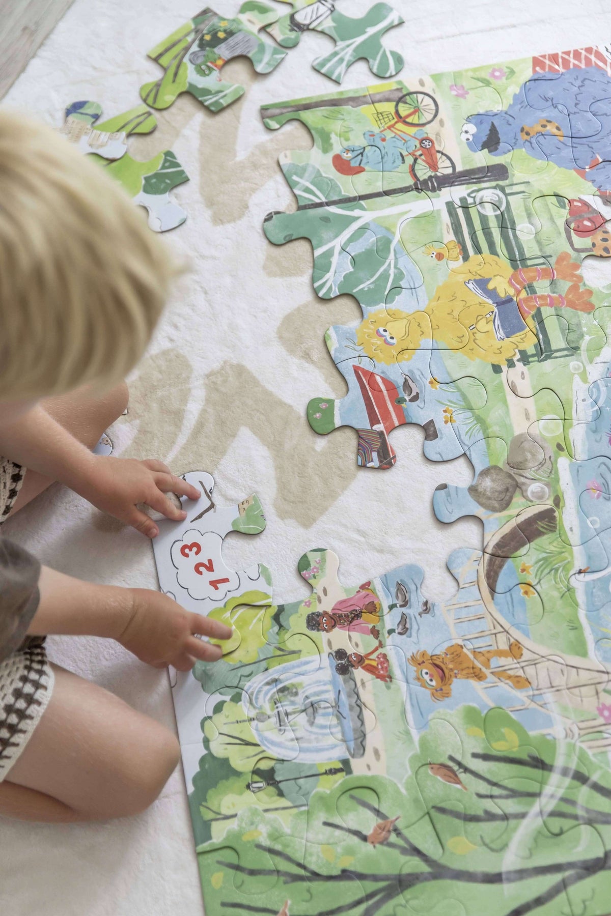 Child engaged with Mindful Moments with Sesame Street Floor Puzzle pieces on a cozy play mat.