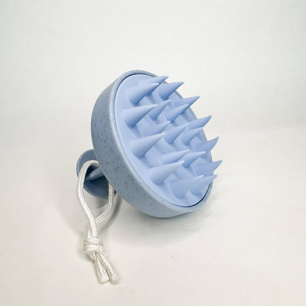 Blue textured ball with a white rope on a light gray background