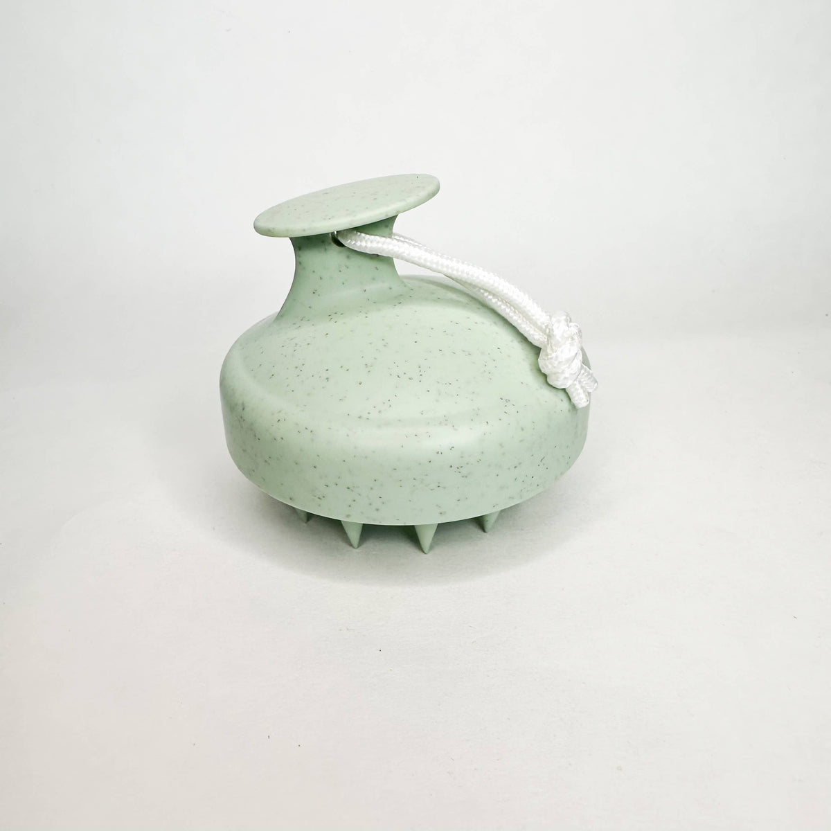 Green scalp massager on a white background