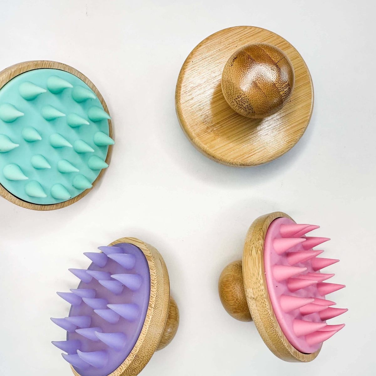 Four textured pet toys with wooden bases on a white background