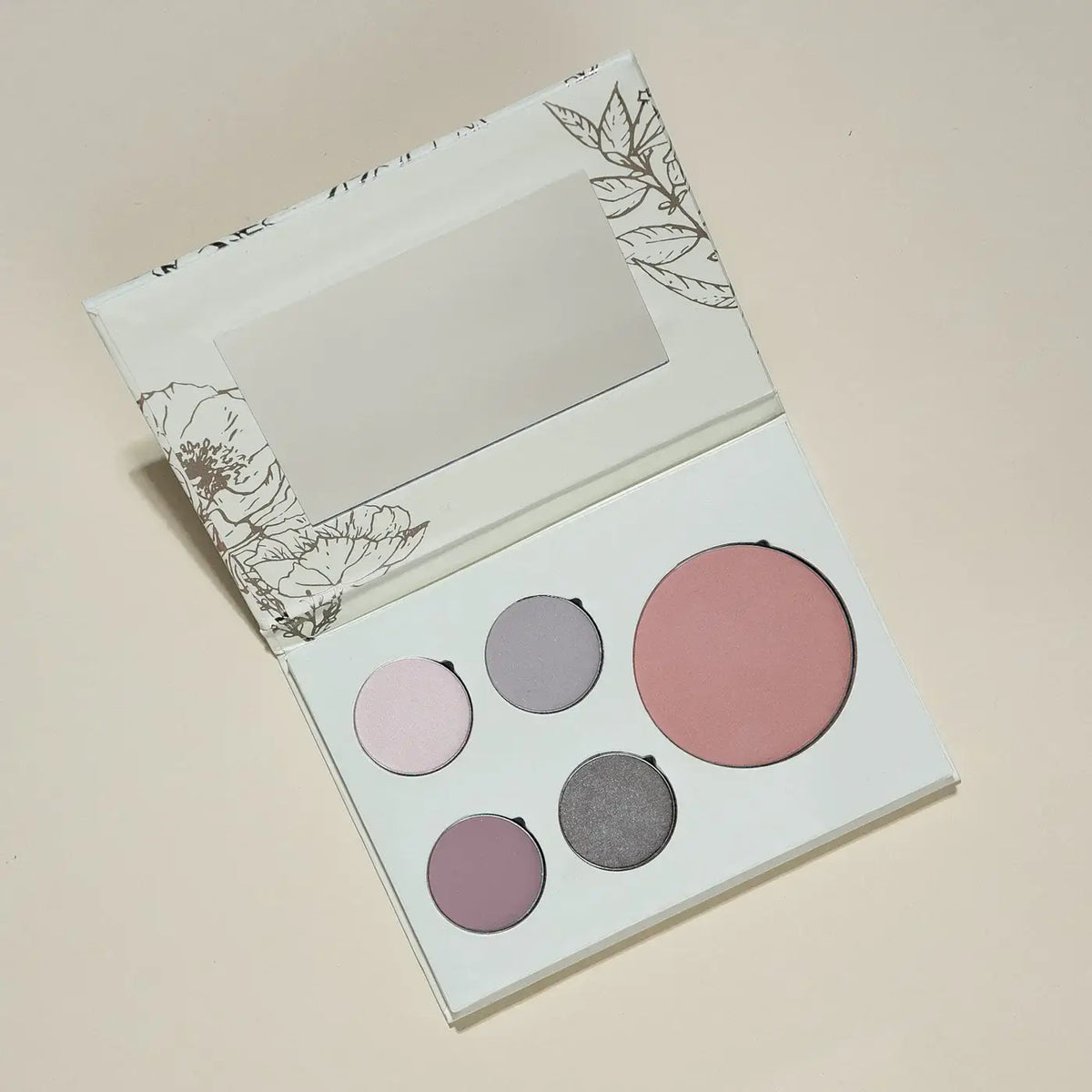 Makeup palette with four round shades on a beige background