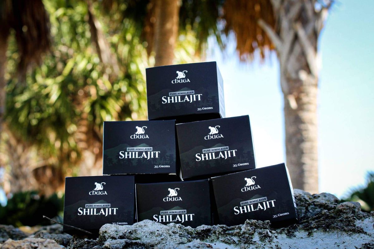 Stack of Shilajit boxes with a natural outdoor background