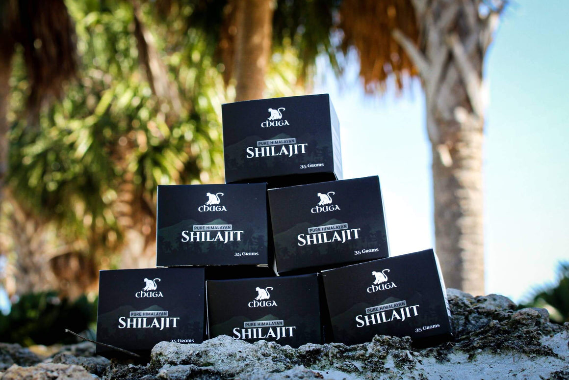 Stack of Shilajit boxes with a natural outdoor background