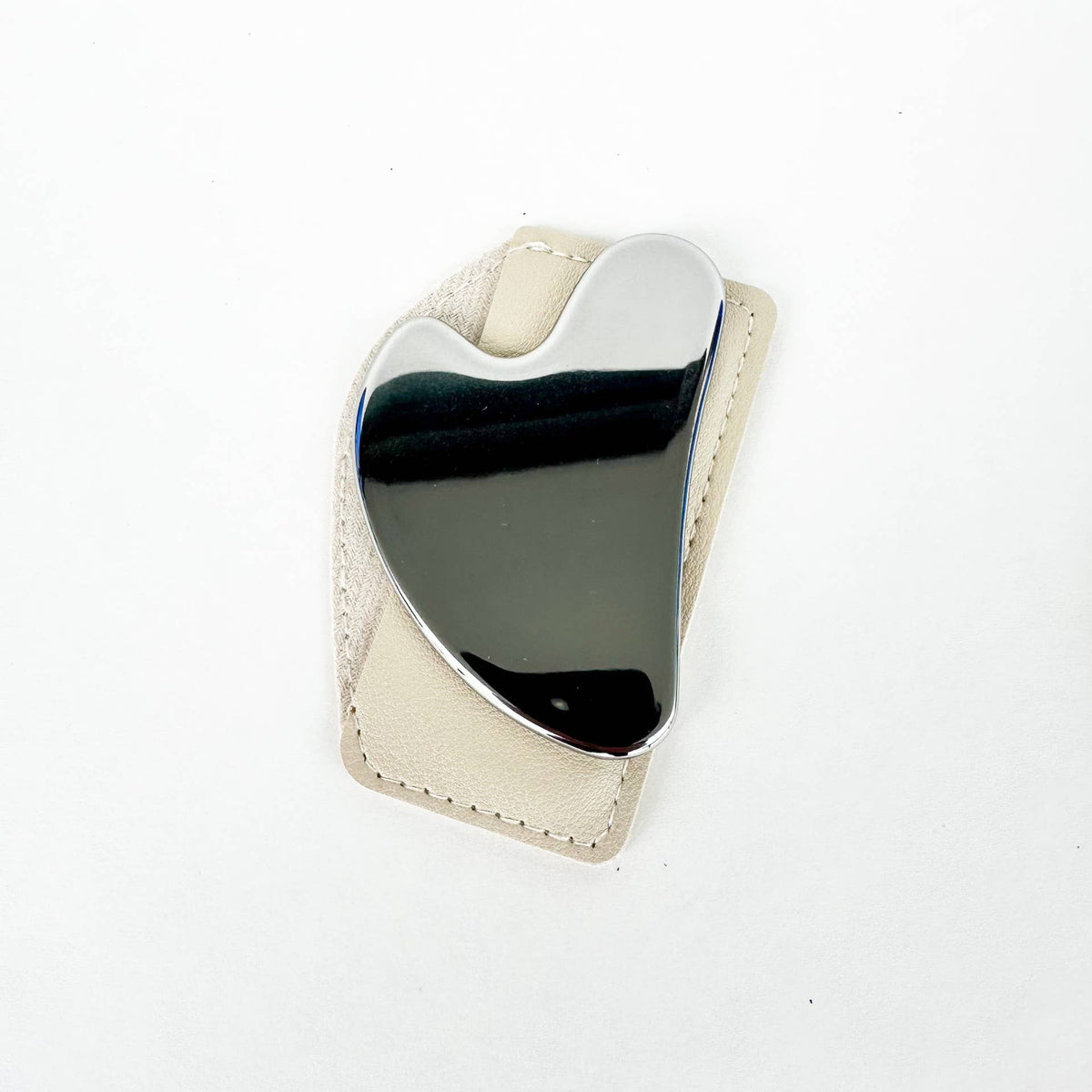 Heart-shaped object with metallic surface on a white background