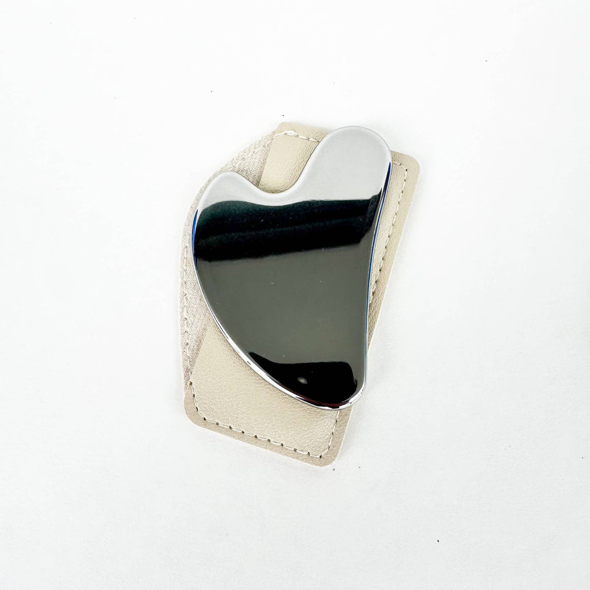 Heart-shaped object with metallic surface on a white background