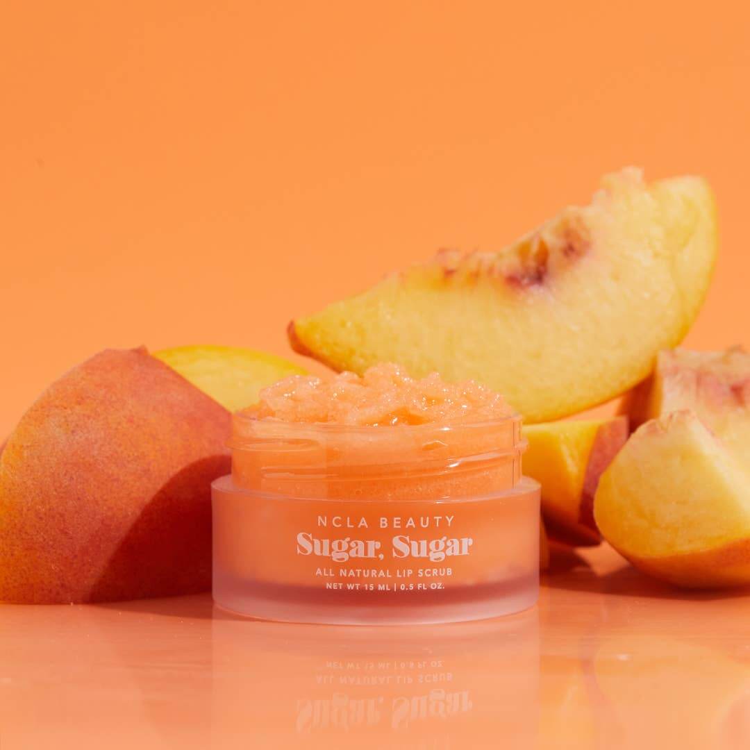 NCLA Beauty Sugar, Sugar lip scrub with peach slices on an orange background