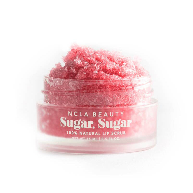 Pink lip scrub in a clear container with 'NCLA Beauty' branding on a white background