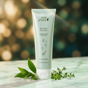 Tube of Tea Tree Detox Cleanser with green leaves on a wooden surface