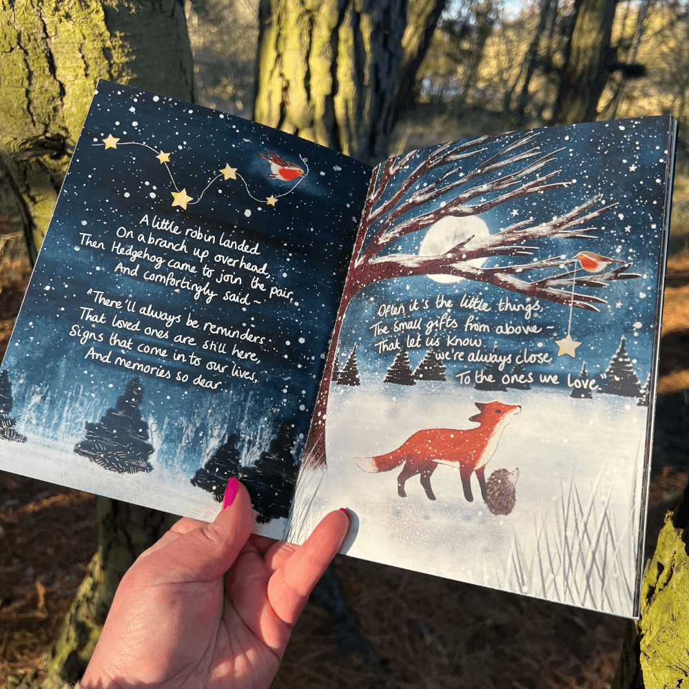The Longest Night Paperback Book + bookmark open to illustrated pages with winter scene and heartfelt text.