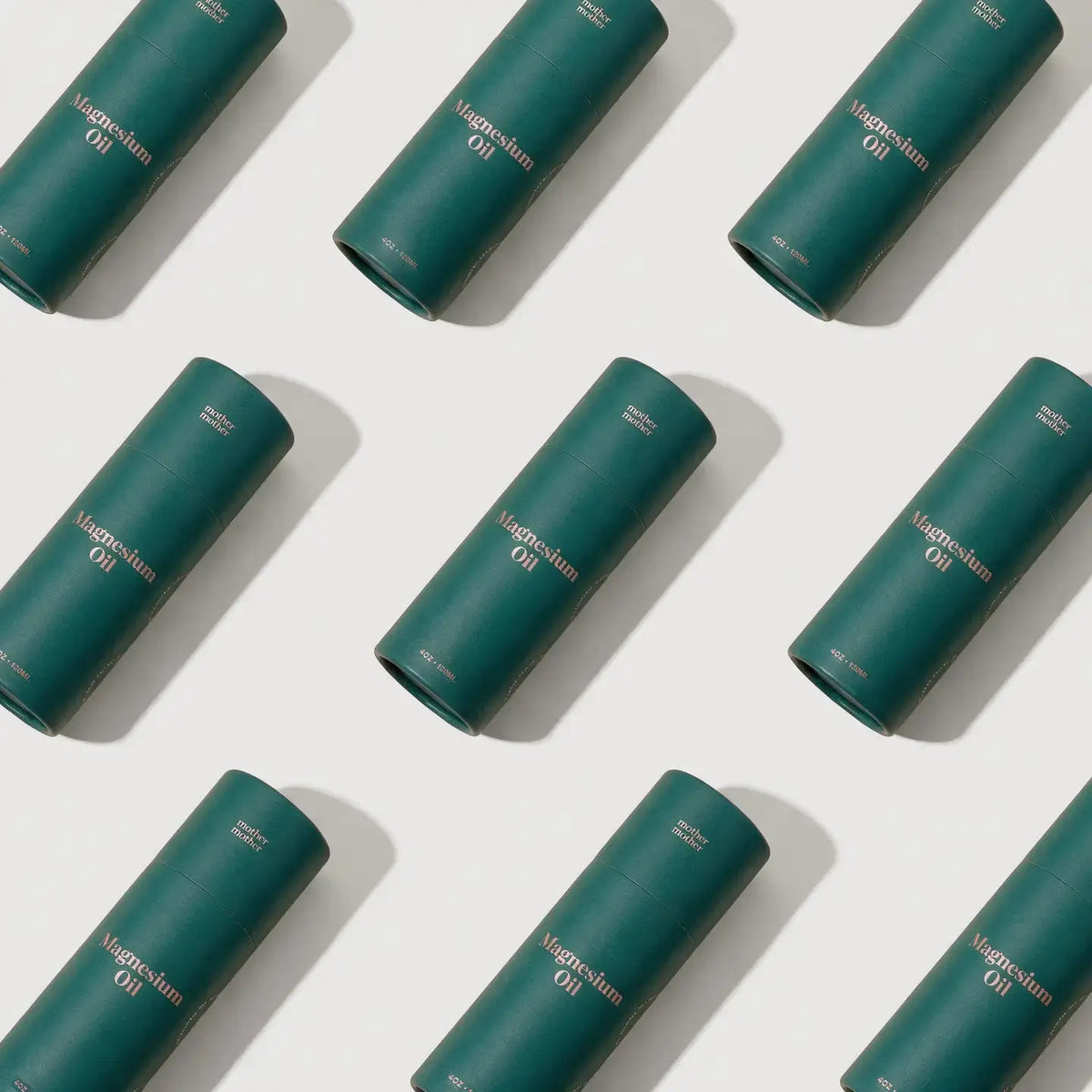 Multiple green cylindrical containers labeled 'Magnesium Oil' arranged in a pattern on a white background.