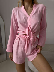 Model wearing UNDRESS Two-Piece Lounge Set, featuring a pink button-up top and matching shorts.