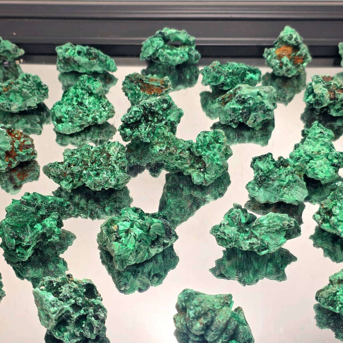 Velvet Malachite Crystals Natural 200g displayed on a reflective surface with vibrant emerald-green hues.