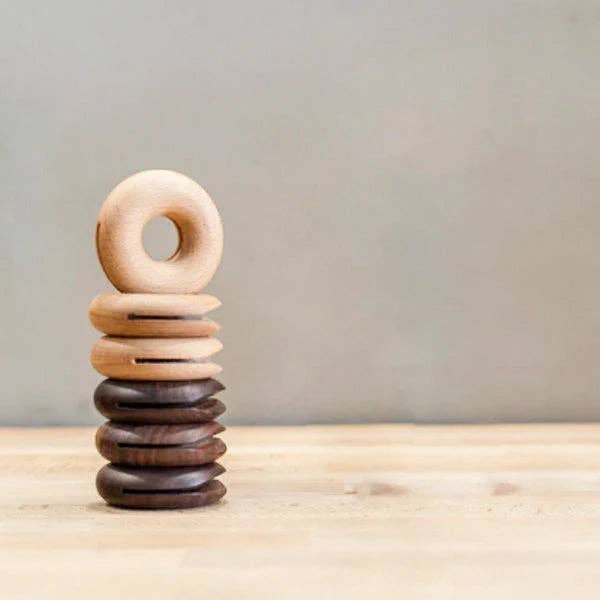 Stack of wooden rings on a wooden surface with a neutral background
