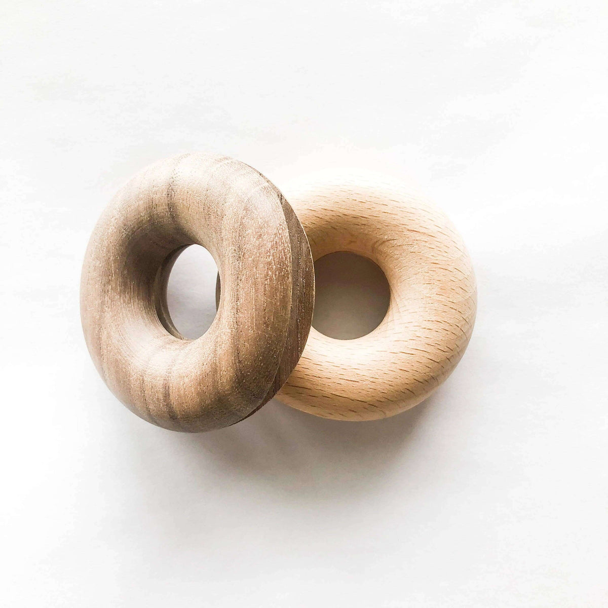 Two wooden donut-shaped objects on a white background