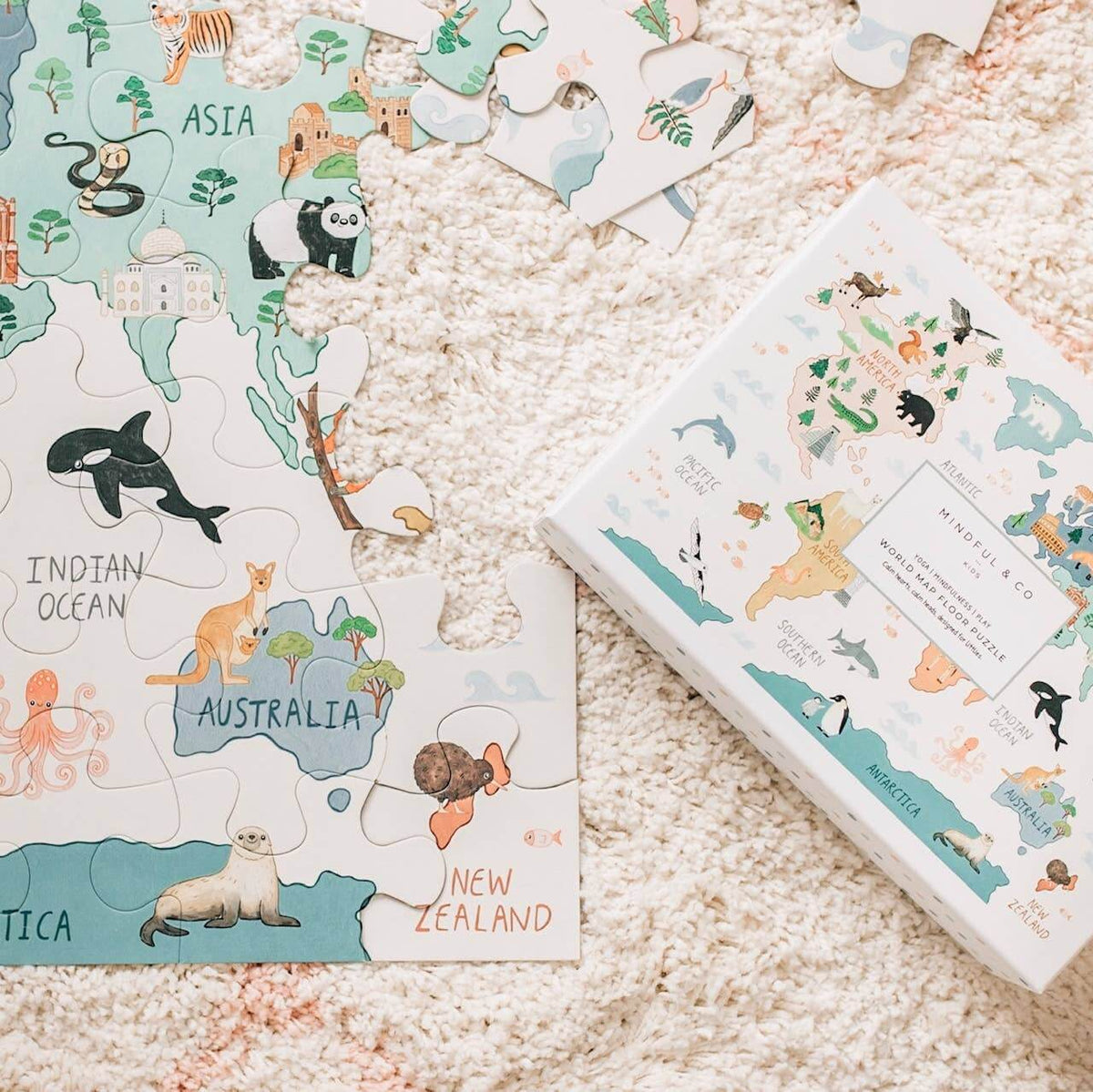 World Map Floor Puzzle pieces featuring animals and continents on a soft beige rug.