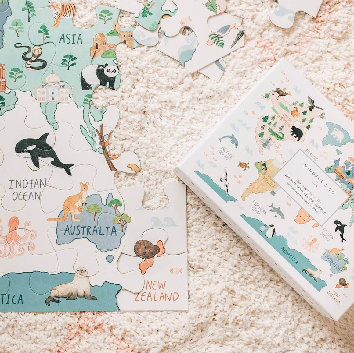 World Map Floor Puzzle pieces featuring animals and continents on a soft beige rug.