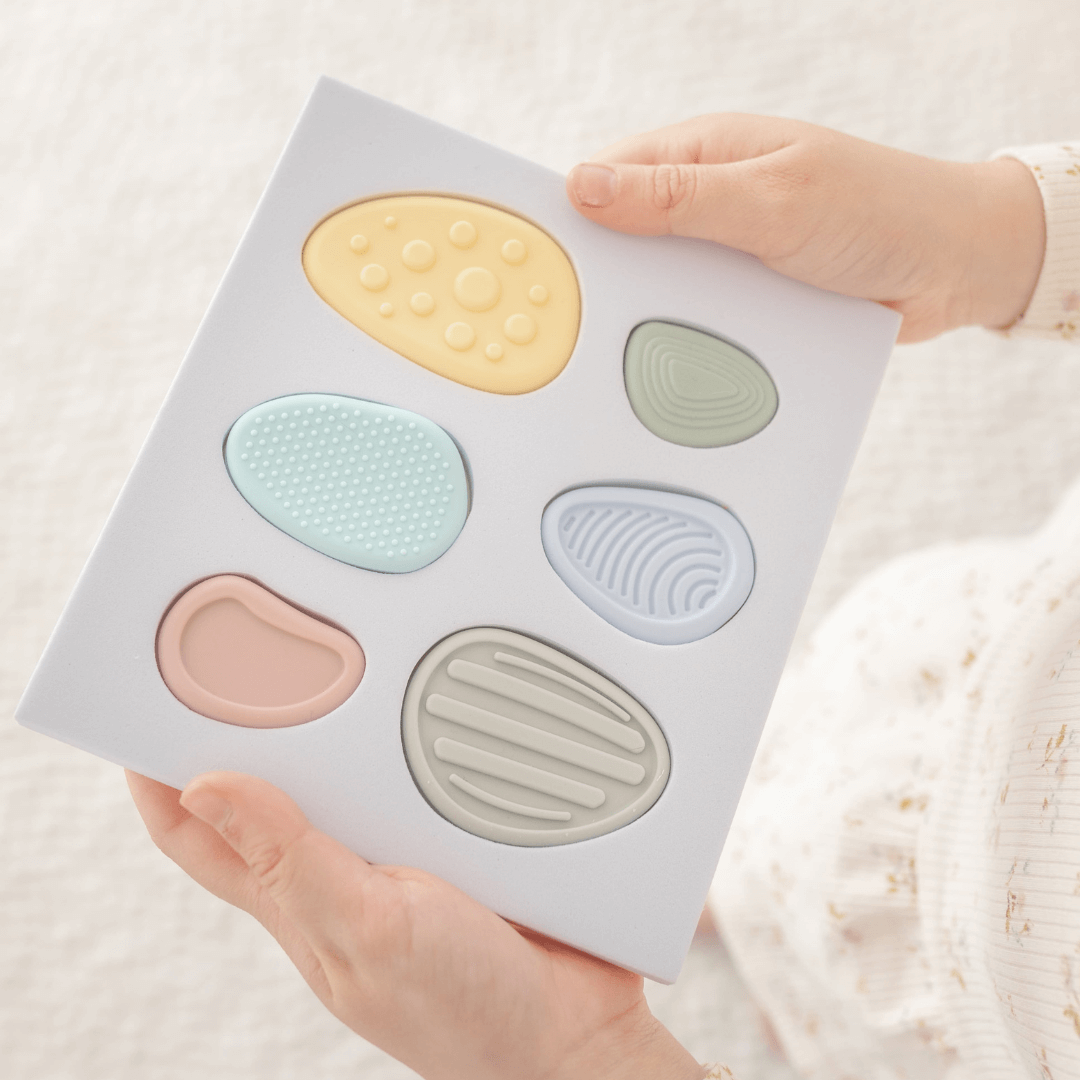 Worry Stones – Calming Sensory Fidget for Kids (Set of 6) held by a child, showcasing soft silicone textures in pastel colors.