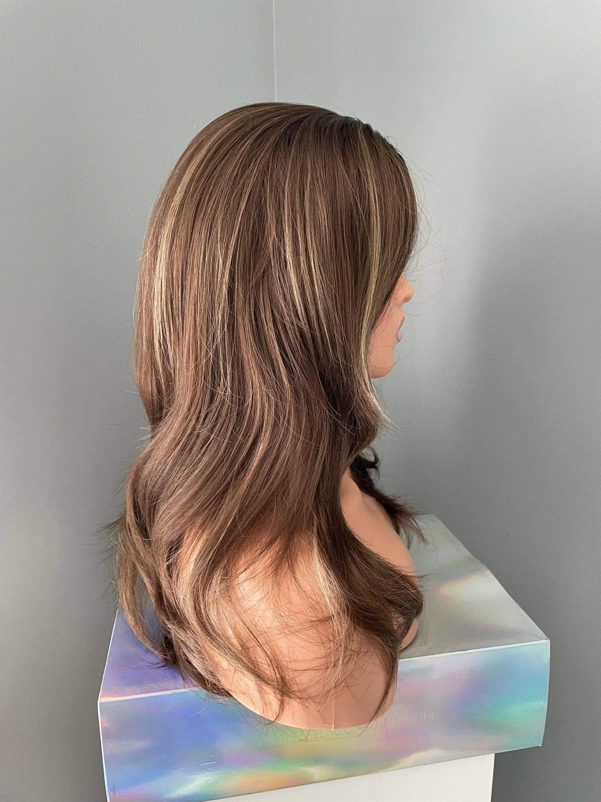 Yaz brown layered wig with blonde highlights showcasing soft waves and natural movement from a side view.
