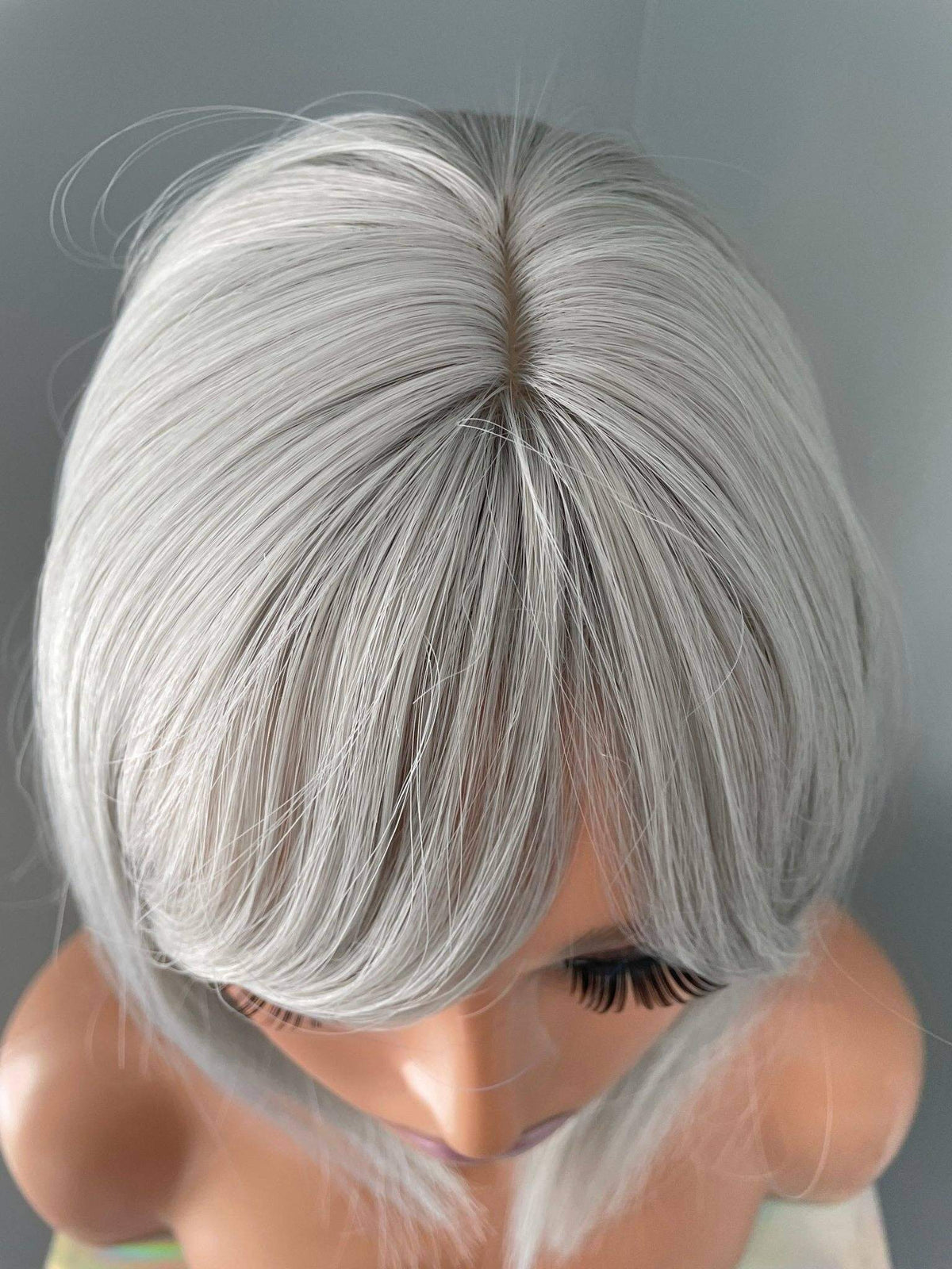 Top view of the Yvette Short Silver Bob Wig showcasing its sleek ash silver color and soft side-swept bangs.