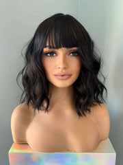 Woman with styled black hair against a neutral background