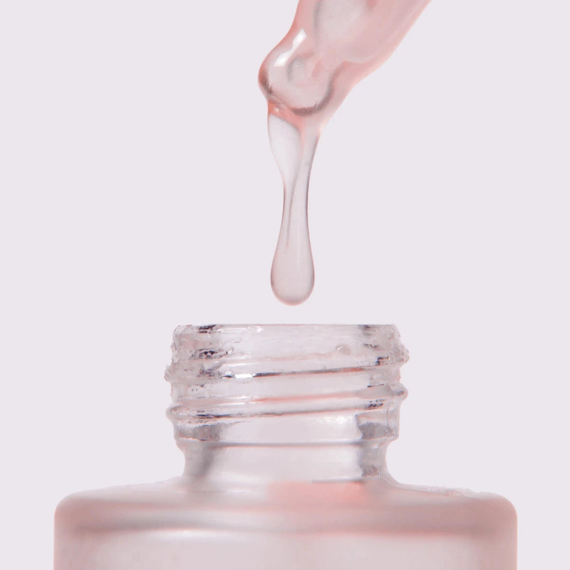 Glow Serum dropper extracting serum from the bottle, highlighting the luminous texture of the product.
