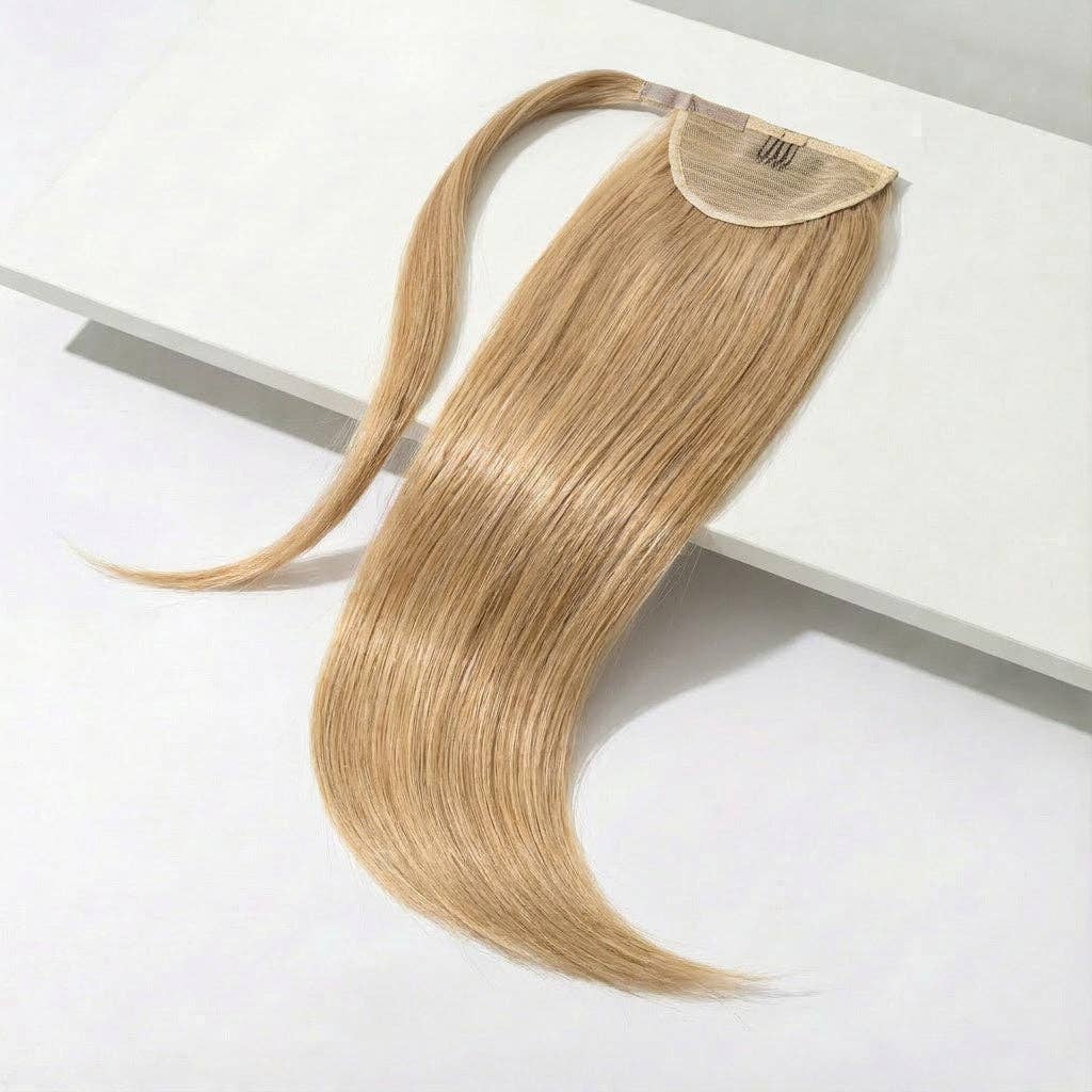 darkest blonde ponytail hair extension displayed on a white surface, showcasing its silky straight design and wrap-around feature.