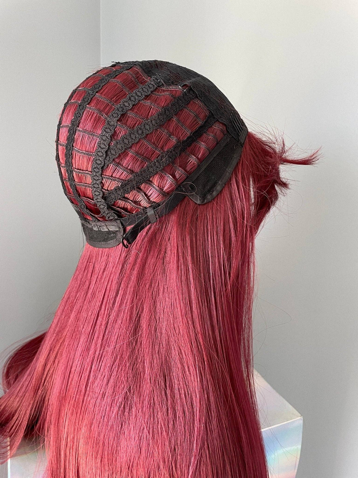 Long wine red silky straight wig with bangs showing the interior cap construction and natural flow of the hair.