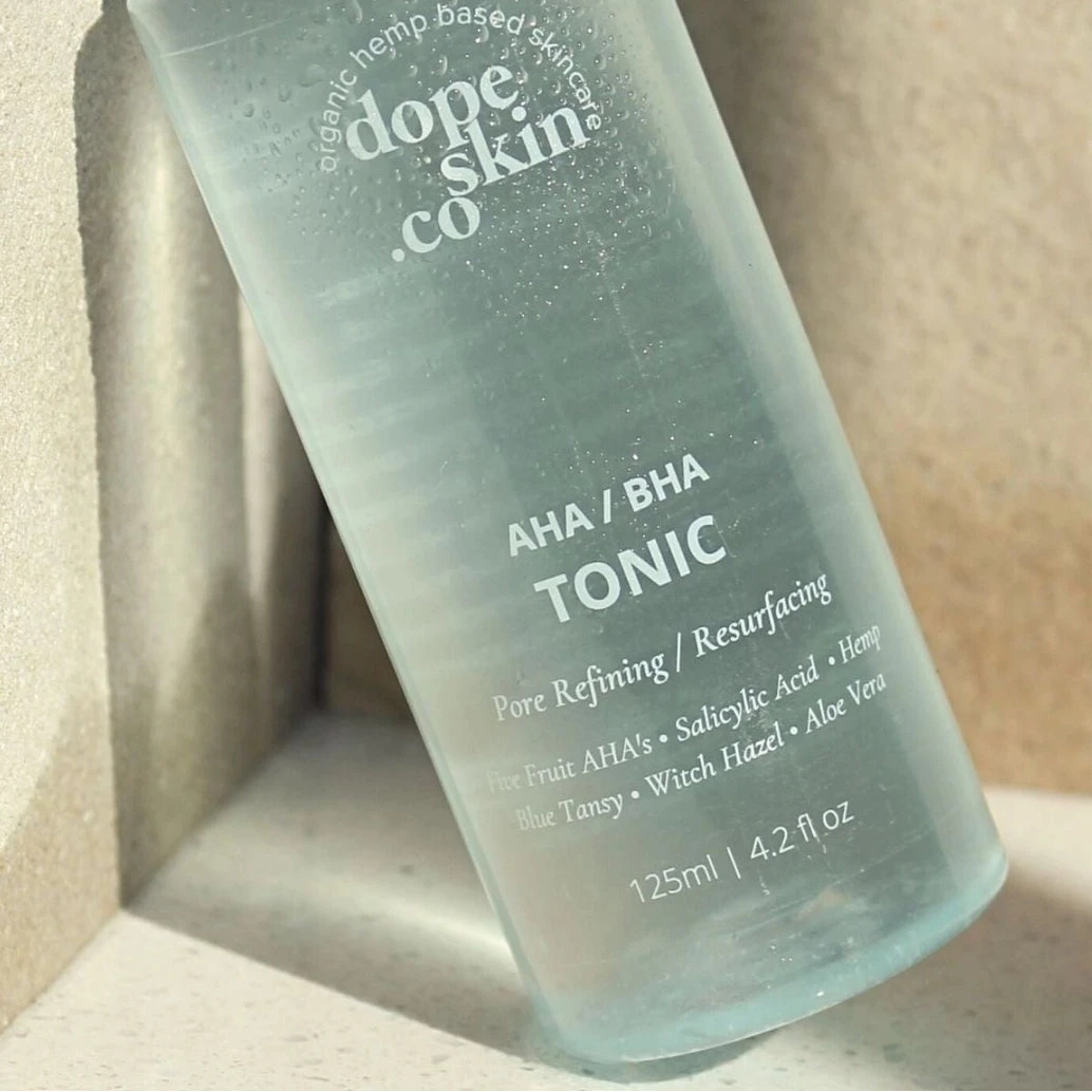 Bottle of AHA/BHA Tonic from dope skin co on a neutral background