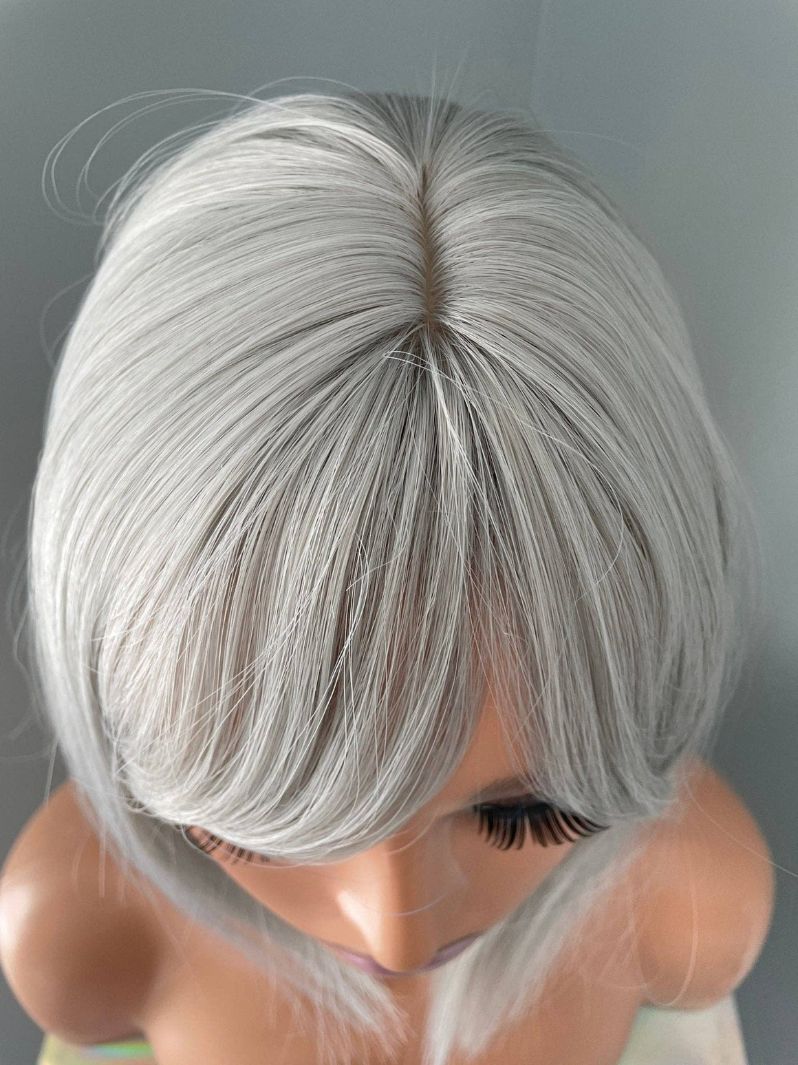 Top view of the Yvette Short Silver Bob Wig showcasing its sleek ash silver color and soft side-swept bangs.