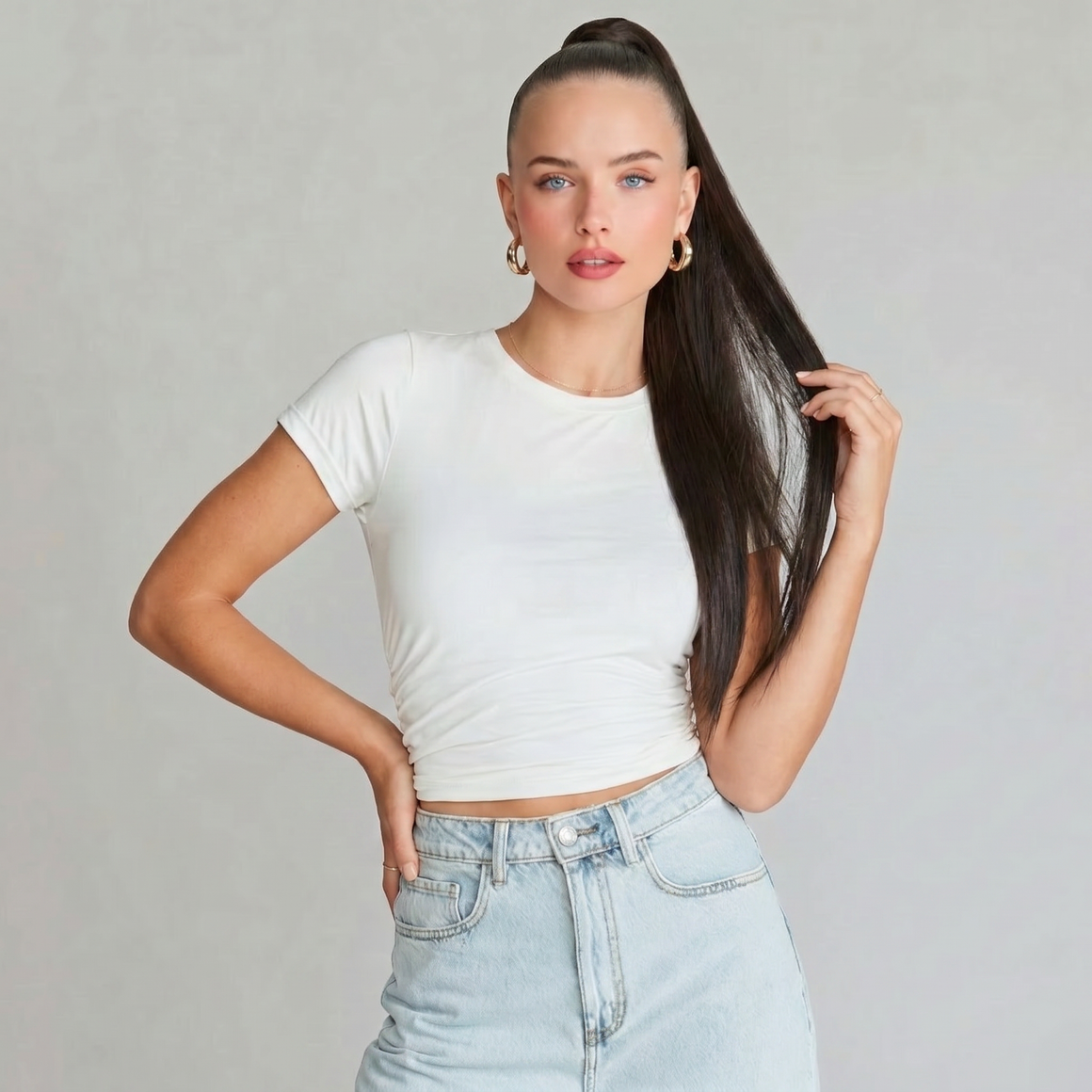 Model wearing a white t-shirt and high-waisted jeans showcasing a chocolate brown ponytail hair extension.